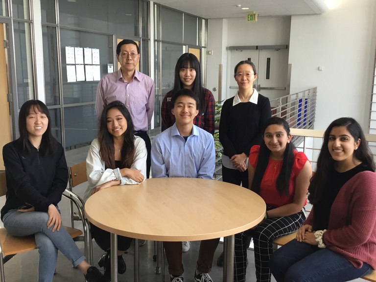 Group photo of lab members sitting around a round table