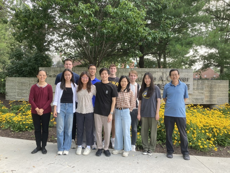 Group photo, outside in front of yellow flowers