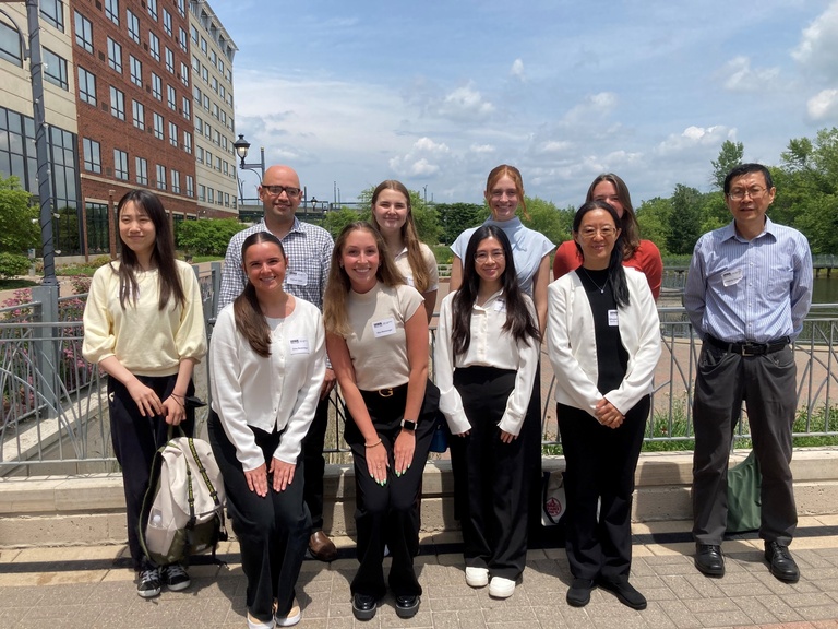 Lab members group photo, outdoors with a blue sky