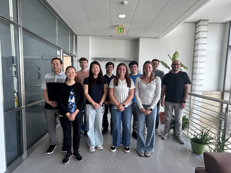 Lab members group photo, indoors on a balcony