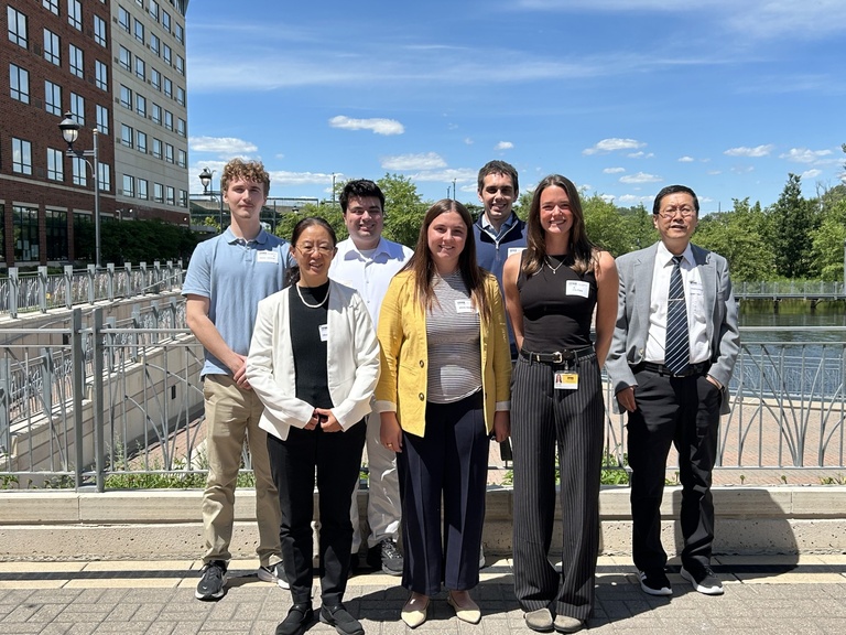 Lab members group photo, outdoors with a blue sky